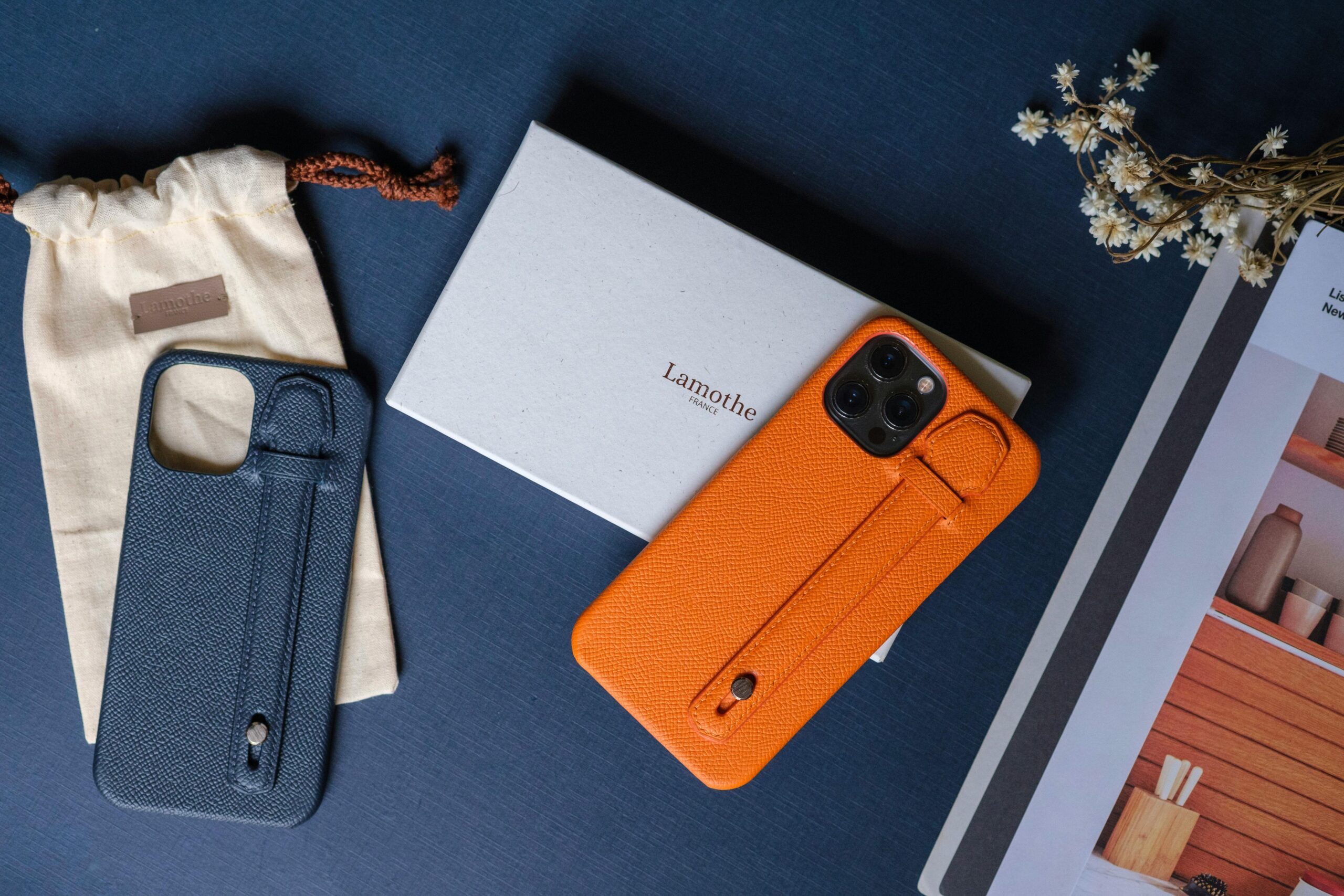 Elegant leather phone cases displayed with accessories on a dark table.